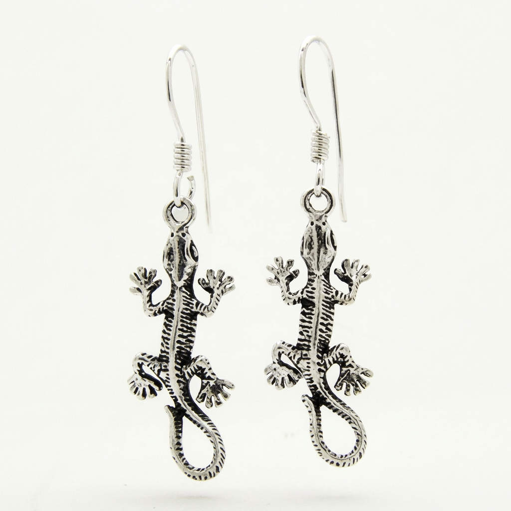 Pair of textured sterling silver lizard earrings with curled tails and French hooks on white.