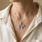 Sterling silver bear pendant worn on a display chain with a cream linen shirt.